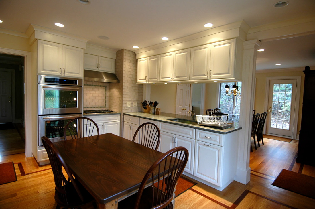 Finished kitchen with detailed cream cabinetry and a warm wood dining table